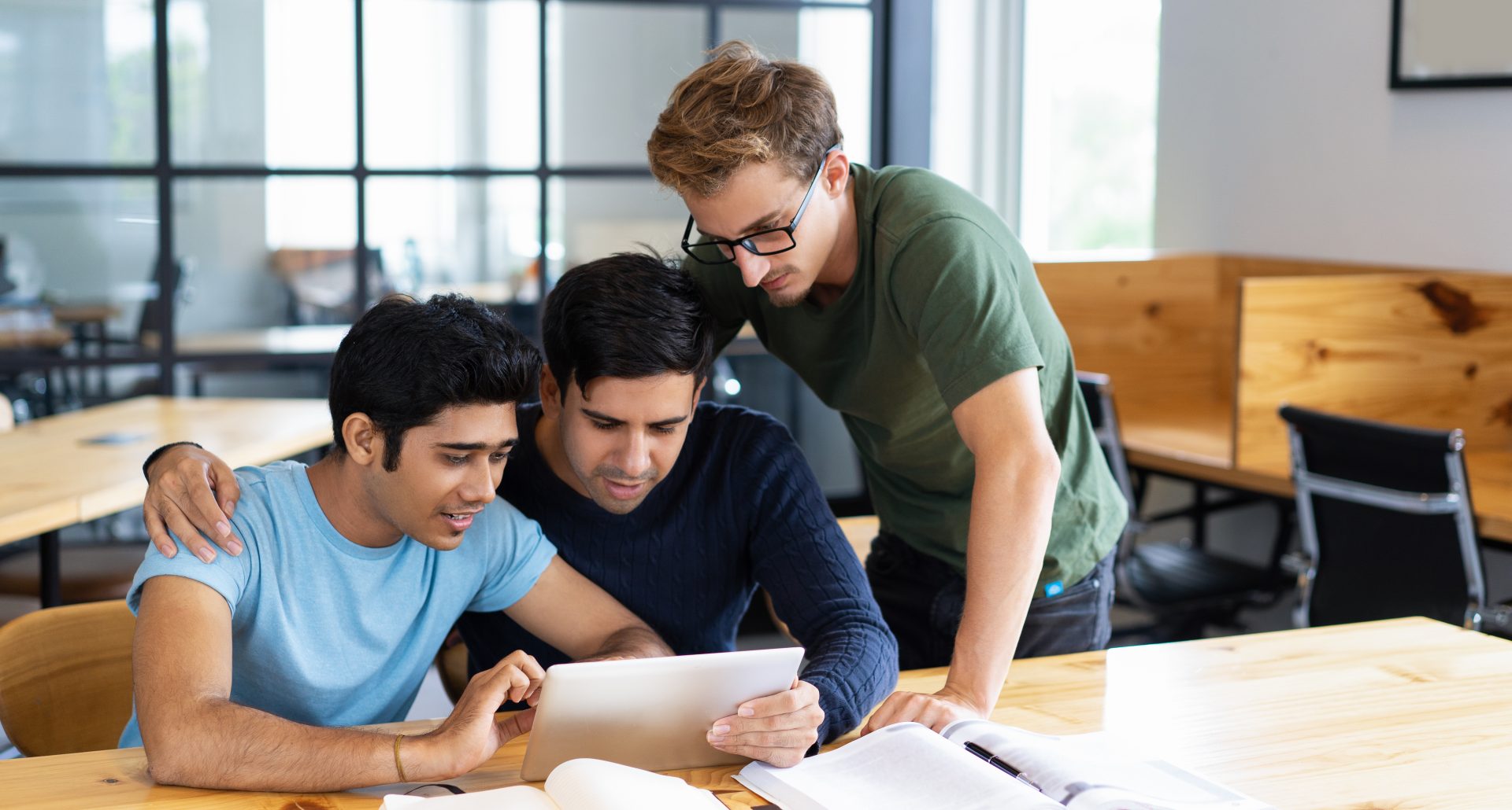 Focused students browsing on tablet computer and talking