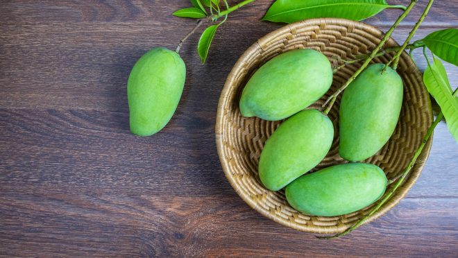 Fresh green mango fruit in a wooden basket