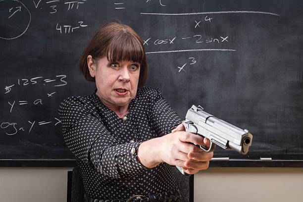 A grumpy older female teacher in front of the classroom